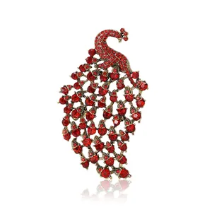 Vintage bronze peacock brooch with deep red rhinestones and elegant curved tail feathers
