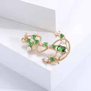 Navy style anchor brooch with green square gemstones and white pearls on golden metal