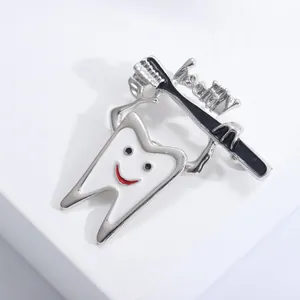 Macro detail of tooth and toothbrush enamel brooch with Healthy text engraving