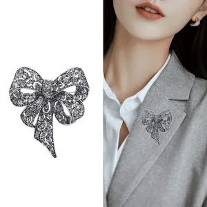 Spilla vintage a fiocco con strass grigi su abito e sfondo bianco isolato