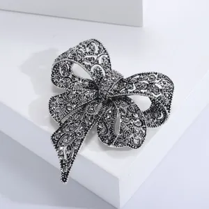 Macro di una spilla a fiocco in argento con strass scuri e lavorazione in filigrana