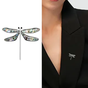 Elegant dragonfly brooch with iridescent abalone shell wings on silver metal frame