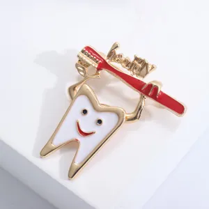 Macro detail of tooth and toothbrush brooch with healthy engraving on white stand