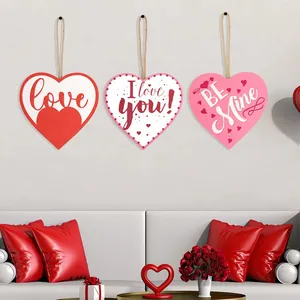 Τρία ξύλινα κρεμαστά καρδιές με Love, I Love You και Be Mine σε έναν λευκό τοίχο