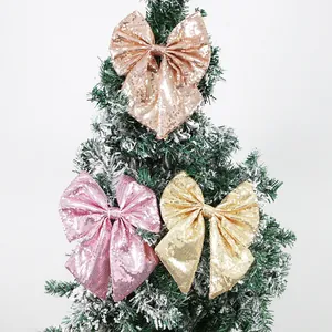 Sequined Christmas bow set in rose gold, pink and gold on a snowy holiday tree