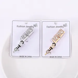 Détails macro des broches peignes dorées et argentées avec strass et accents d'émail