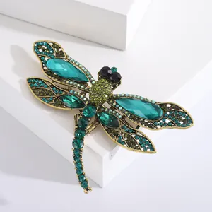 Exquisite antique gold dragonfly brooch featuring vibrant green and blue crystal accents