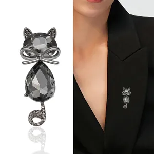 Fashionable crystal cat brooch with silver bow and rhinestones on a black suit lapel