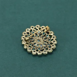 Détail du revers de la broche fleur vintage montrant le fermoir de sécurité en métal doré