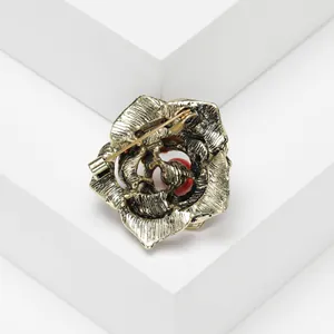 Vue détaillée du dos d'une broche rose dorée montrant le fermoir de sécurité épingle