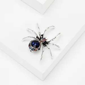 Detailed view of spider brooch with large blue centerpiece and multicolored crystals