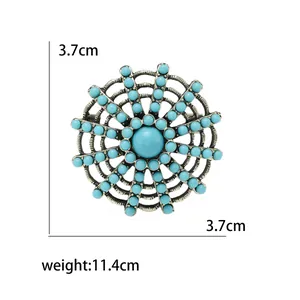 Vintage silver-tone circular brooch with turquoise beads and intricate mesh design