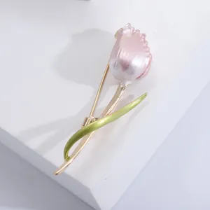 Elegant enamel tulip brooch with pink petals and gold stem on a minimalist background