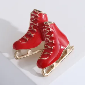 Broche creativo de patines con esmalte rojo vibrante y acabado en tono dorado pulido