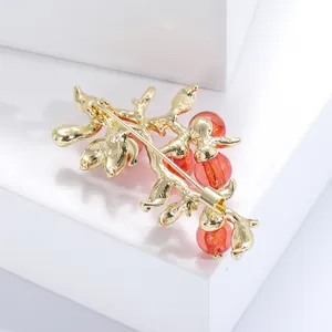 Dettaglio del retro della spilla a forma di frutto con chiusura a spillo e placcatura oro