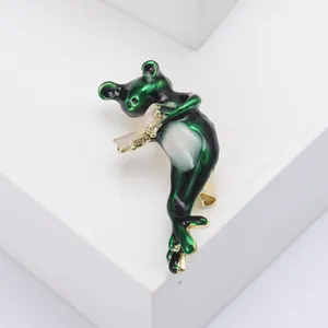 Detailansicht der Frosch-Brosche mit Emaille, die ein goldenes Blasinstrument spielt