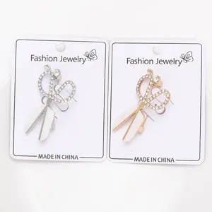 Detalle de broches de tijera con diamantes de imitación brillantes y hojas nacaradas