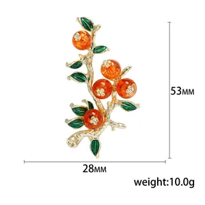 Spilla a ramo di cachi dorato con bacche arancioni, misura 53mm x 28mm e pesa 10 grammi