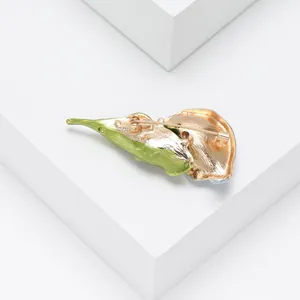 Détail de la broche émaillée en forme de feuille verte avec dos en métal doré