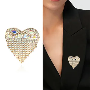 Spilla a cuore elegante con strass iridescenti e nappe sul bavero di un abito nero