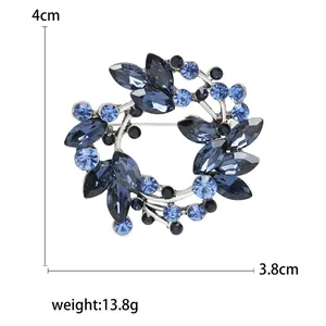 Elegant crystal olive wreath brooch with blue rhinestones measuring 4cm by 3.8cm