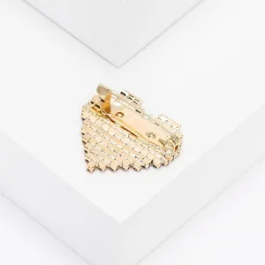 Detail of gold heart brooch with red rhinestones and secure metal pin back fastener