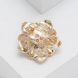 Detalle de la estructura dorada posterior y el alfiler de este broche floral