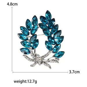 Elegant olive branch crystal brooch with blue marquise stones and white rhinestones