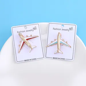 Detailed view of fashionable red and blue airplane enamel brooches on jewelry cards