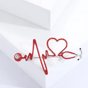 Vue détaillée d'une broche stéthoscope avec cœur en émail rouge et cristal scintillant