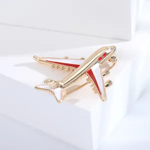 Detailed close-up of a white and red enamel aircraft brooch with gold-tone plating