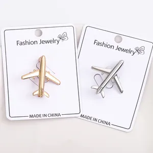 Detailed close-up of sleek gold and silver airplane lapel pins on a display card