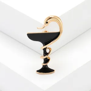 Broche en émail serpent et bol dorée avec finition noire élégante sur fond blanc