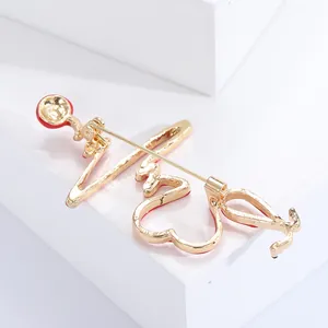 Détail de la broche stéthoscope EKG plaquée or avec émail rouge et épingle au dos