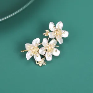 Macro shot of elegant floral brooch with pearl luster petals and gold zircon details