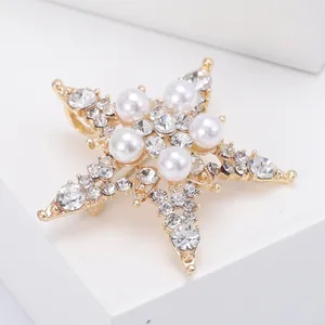 Detail view of gold star brooch with white pearls and sparkling crystal rhinestones