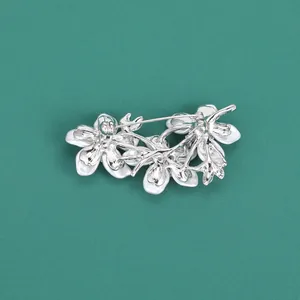 Detailed back view of silver flower brooch showing secure pin fastener and metal frame