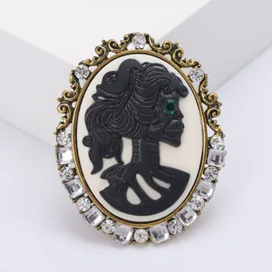 Vintage cameo brooch with black skull portrait and crystal embellishments on bronze frame