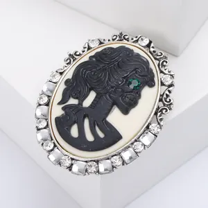 Macro detail of gothic vintage cameo brooch with skull relief and crystal border