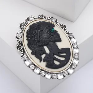 Vintage Gothic cameo brooch with silver frame, crystal accents and green gem eye