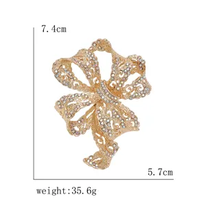 Elegant gold bow brooch with colorful rhinestones measuring 7.4cm by 5.7cm in size