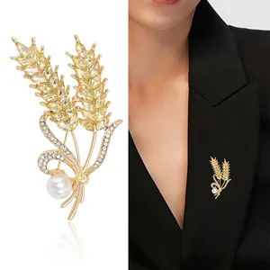 Elegant gold wheat brooch with champagne crystals and pearl pinned on a black blazer