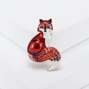 Detailed close-up of a red enamel fox brooch with colorful rhinestones on a white base