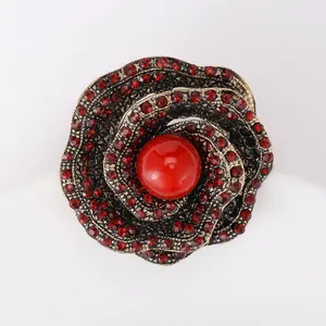 Macro shot of retro gun black rose brooch featuring vibrant red crystals and petals