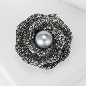 Macro view of rose brooch featuring grey pearl center and dark grey crystals