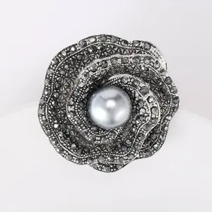 Macro shot of retro gun black rose brooch with full crystal inlay and large grey pearl