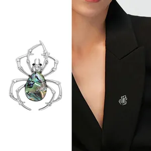 Vintage spider brooch with abalone shell and crystal accents on a silver metal frame