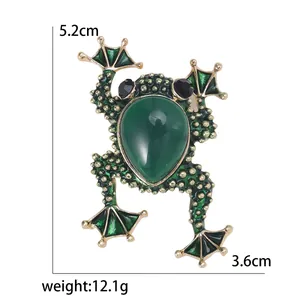 Vintage green enamel frog brooch with emerald green gemstone and gold metallic details