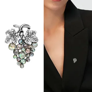 Vintage grape brooch with abalone shell beads and silver leaves on black suit