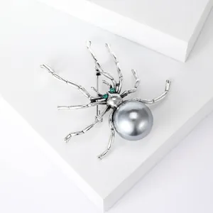 Detailansicht einer silbernen Spinnenbrosche im Vintage-Stil mit grauer Perle und Strass